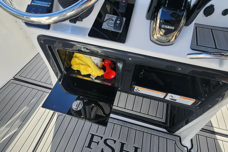 Slide: The Image of Yamaha 255 FSH Sport E 2022 boat dashboard with storage compartments and controls. - 20