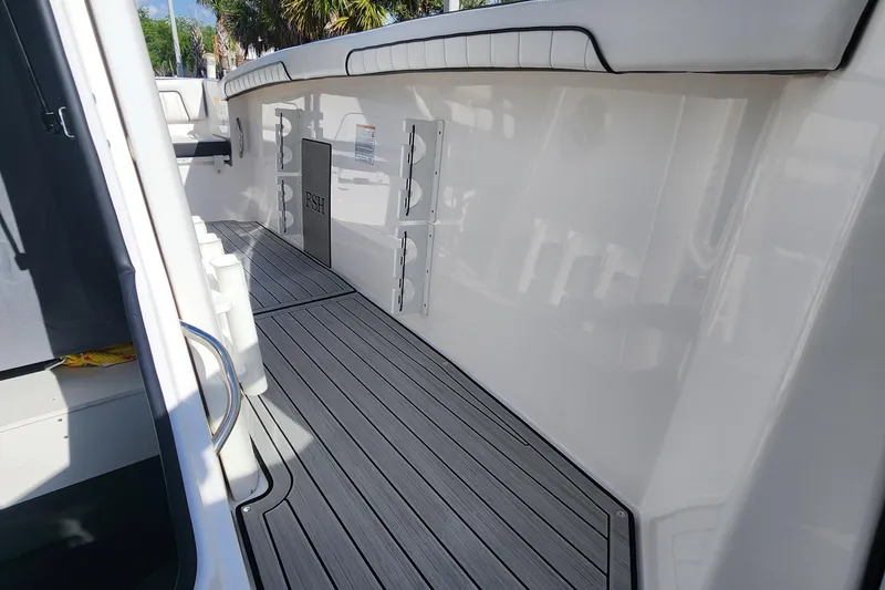 Slide: The Image of 2022 Yamaha 255 FSH Sport E boat interior with sleek deck and storage compartments. - 25