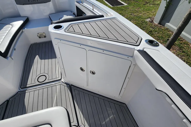 Slide: The Image of 2022 Yamaha 255 FSH Sport E boat interior with sleek seating and storage compartments. - 28
