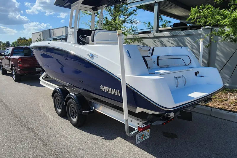 Slide: The Image of 2022 Yamaha 255 FSH Sport E boat on trailer, parked outdoors under clear sky. - 3