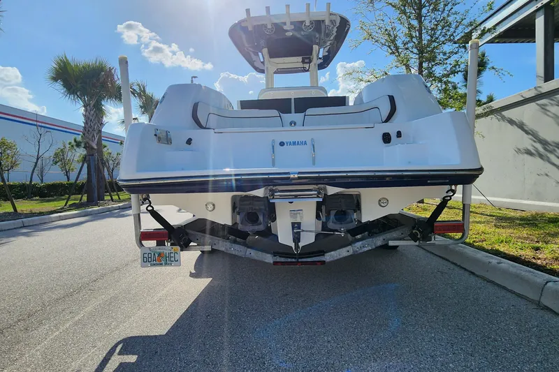Slide: The Image of 2022 Yamaha 255 FSH Sport E boat on trailer, parked under sunny skies. - 38