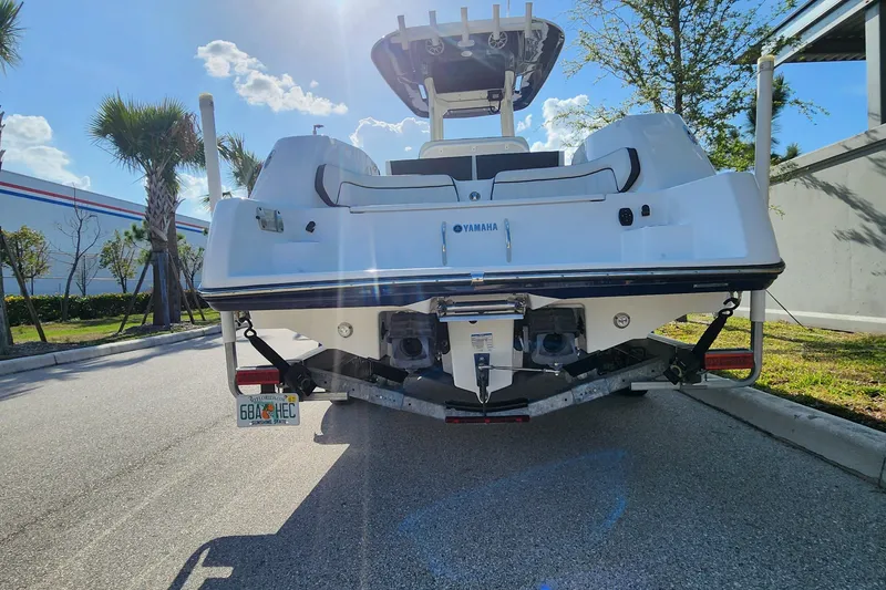 Slide: The Image of 2022 Yamaha 255 FSH Sport E boat on trailer, parked outdoors under clear sky. - 39