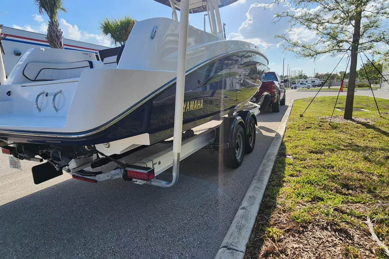 Slide: The Image of 2022 Yamaha 255 FSH Sport E boat on trailer, parked on sunny street. - 41