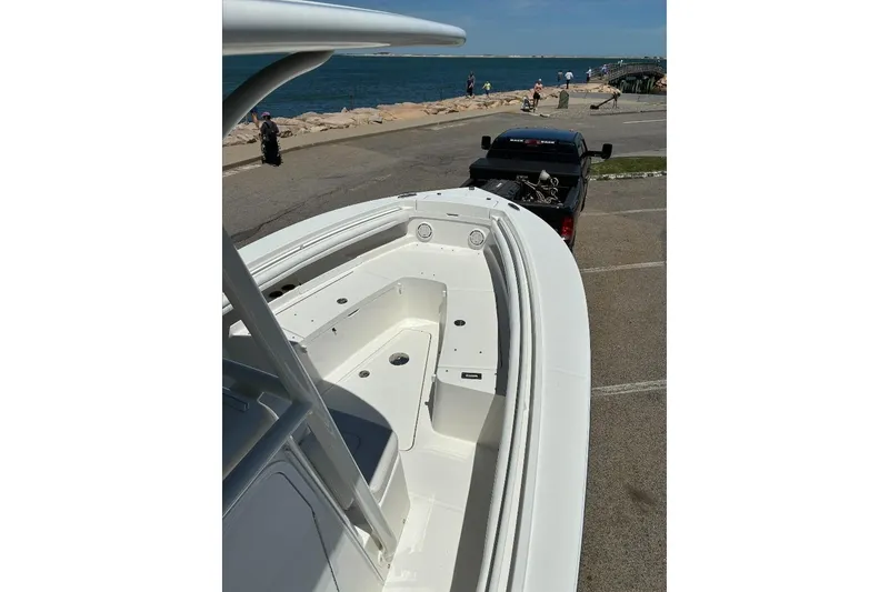 Slide: The Image of 2019 Regulator 23 boat on trailer near ocean, clear sky background. - 14