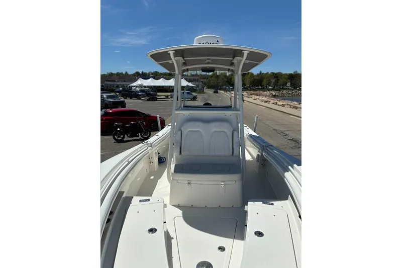 Slide: The Image of 2019 Regulator 23 boat with T-top and seating, parked near waterfront. - 16