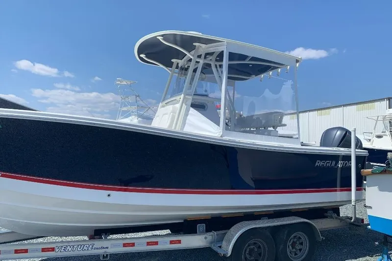 Slide: The Image of 2019 Regulator 23 boat on trailer under clear blue sky. - 7