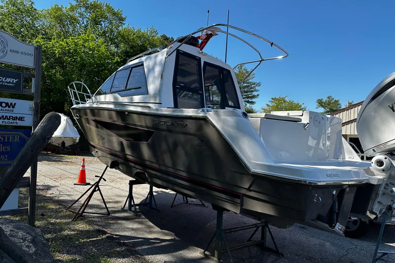 The Image of 2026 Solara S-250 Coupe boat on display, elevated on stands, outdoors. - 0