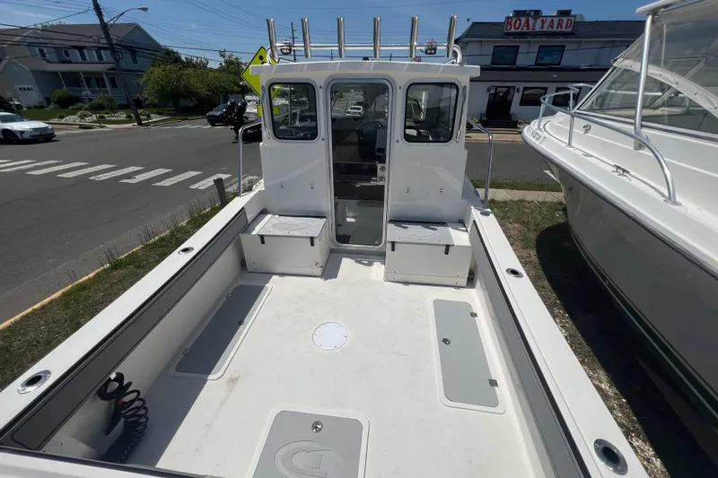 Slide: The Image of 2026 Defiance Admiral 220 EX boat, spacious deck, docked near a boathouse. - 10
