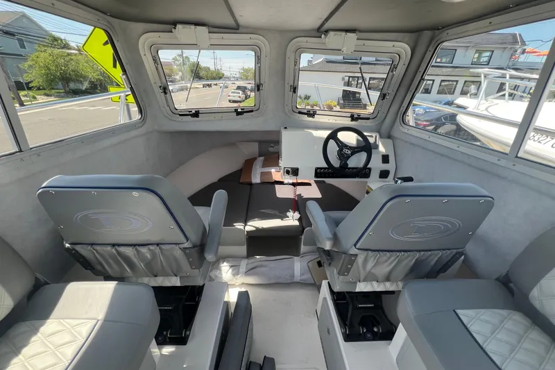 Slide: The Image of Interior of 2026 Defiance Admiral 220 EX boat, featuring modern seating and steering console. - 11