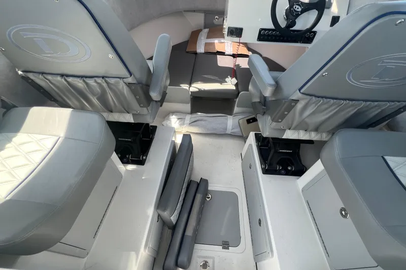 Slide: The Image of Interior of 2026 Defiance Admiral 220 EX boat, featuring gray seating and steering console. - 12