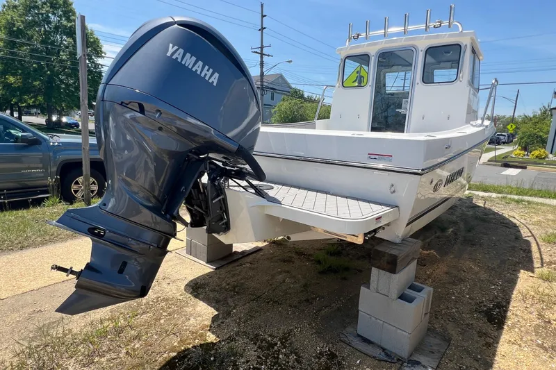 Slide: The Image of 2026 Defiance Admiral 220 EX boat with Yamaha outboard motor on display outdoors. - 9