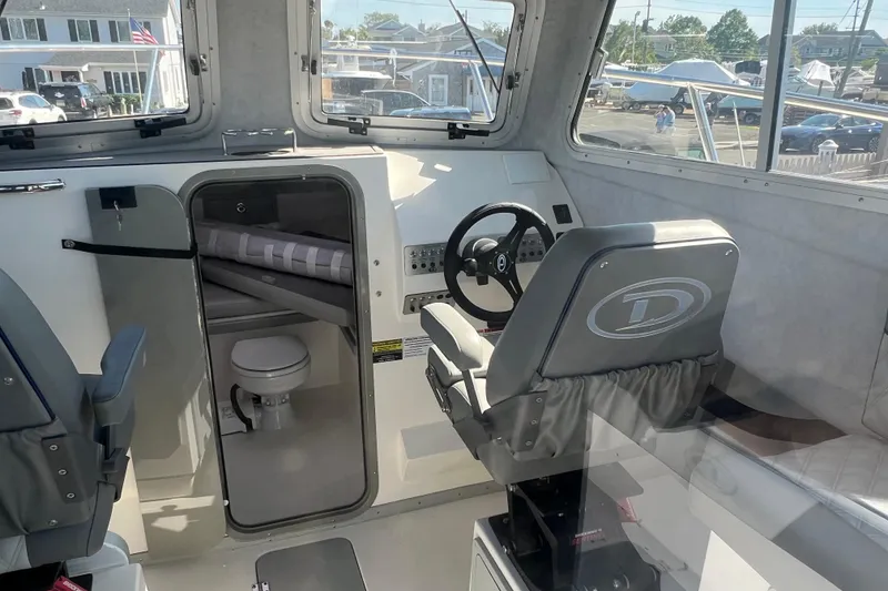 Slide: The Image of Interior of 2025 Defiance Admiral 260 EX boat with steering wheel and cabin view. - 5