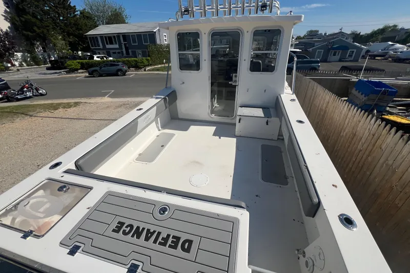 Slide: The Image of 2025 Defiance Admiral 260 EX boat deck, spacious layout, parked near residential area. - 6