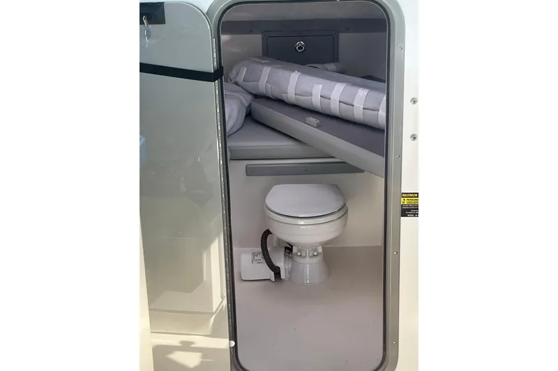 Slide: The Image of 2025 Defiance Admiral 260 EX boat cabin with compact toilet and storage area. - 8