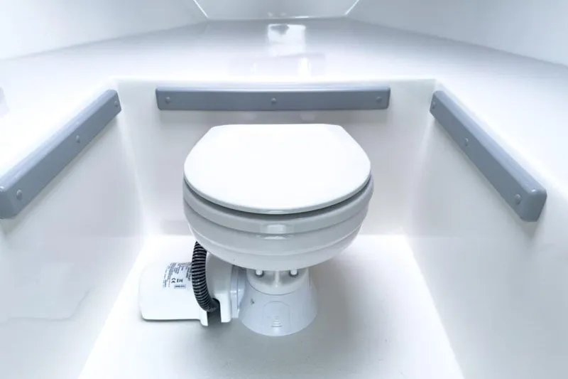 Slide: The Image of Manufacturer Provided Image: 2025 Defiance Admiral 260 EX boat interior with a compact marine toilet. - 9