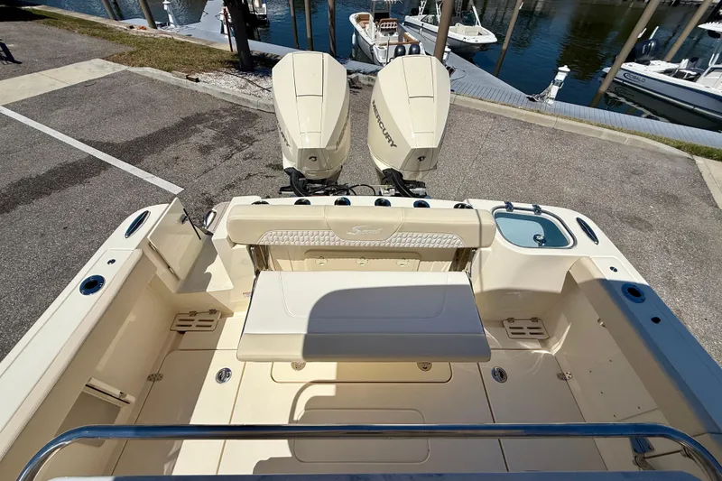 Slide: The Image of 2026 Scout 260 LXF boat with dual Mercury engines at a marina dock. - 24