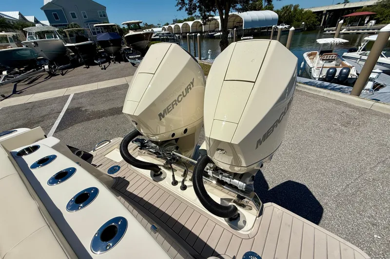 Slide: The Image of 2026 Scout 260 LXF boat with dual Mercury outboard engines at a marina. - 27
