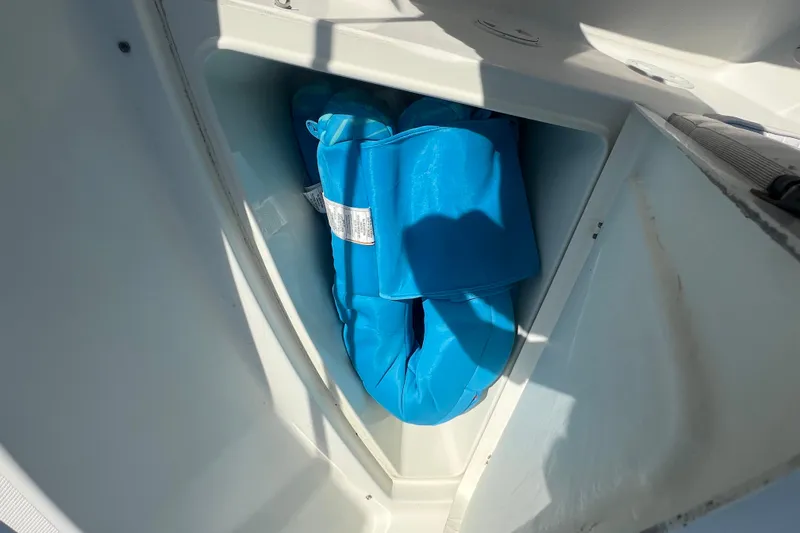 Slide: The Image of Storage compartment on a 2000 Hydra-Sports 230 Seahorse CC with blue life jackets. - 17