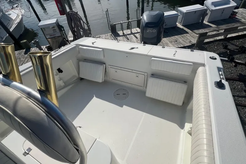 Slide: The Image of 2000 Hydra-Sports 230 Seahorse CC boat interior with seating and storage, docked by the water. - 6