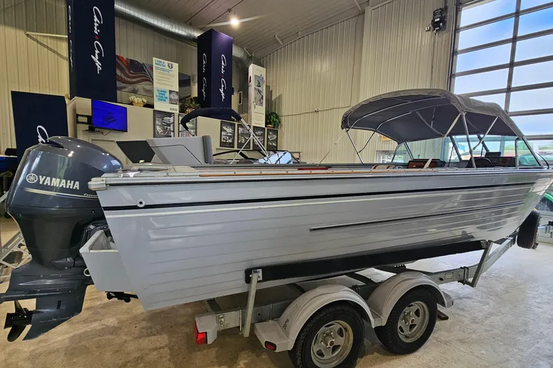 The Image of 1988 Crestliner 2281 boat with Yamaha motor on trailer in showroom. - 1