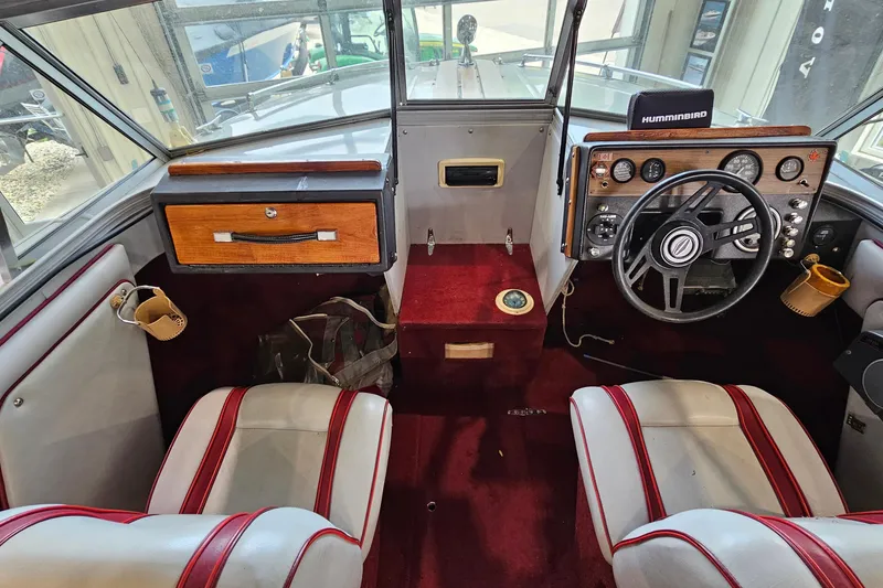 Slide: The Image of Interior of a 1988 Crestliner 2281 boat with red carpet and vintage dashboard. - 11