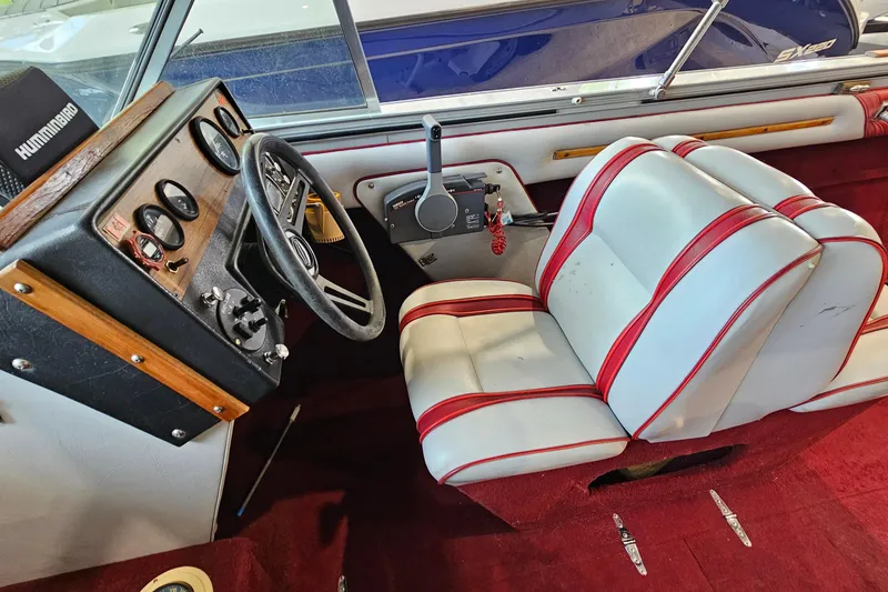 Slide: The Image of 1988 Crestliner 2281 boat interior with red and white seating, steering wheel, and control panel. - 12