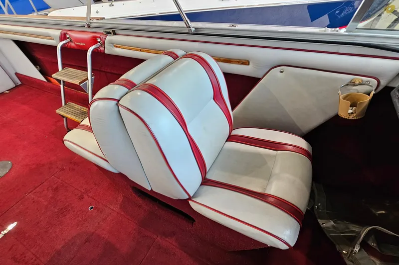 Slide: The Image of 1988 Crestliner 2281 boat interior with red and white seating, wooden steps, and red carpet. - 13