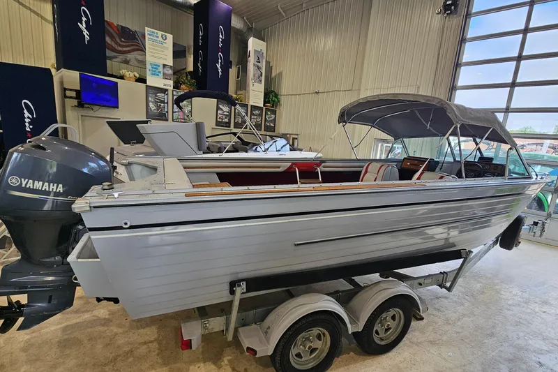 Slide: The Image of 1988 Crestliner 2281 boat with Yamaha motor displayed indoors on a trailer. - 19