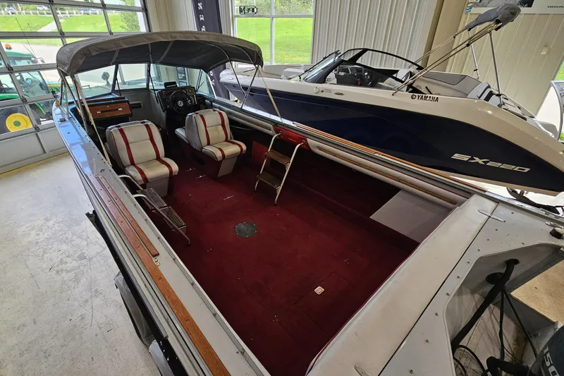 Slide: The Image of 1988 Crestliner 2281 boat with red interior and canopy, displayed indoors. - 6