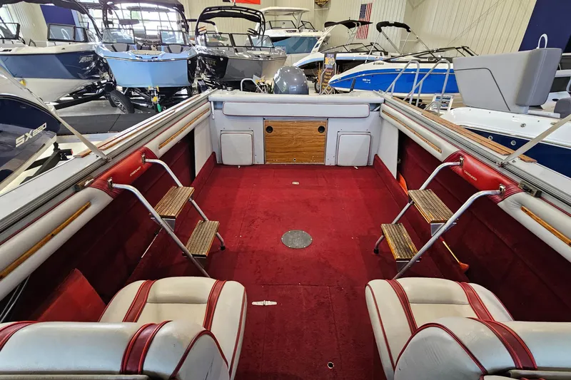 Slide: The Image of 1988 Crestliner 2281 boat interior with red carpet and white seating in showroom. - 8