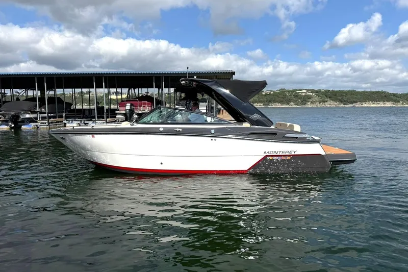 Slide: The Image of 2016 Monterey 258SS Super Sport boat on a lake under a partly cloudy sky. - 13