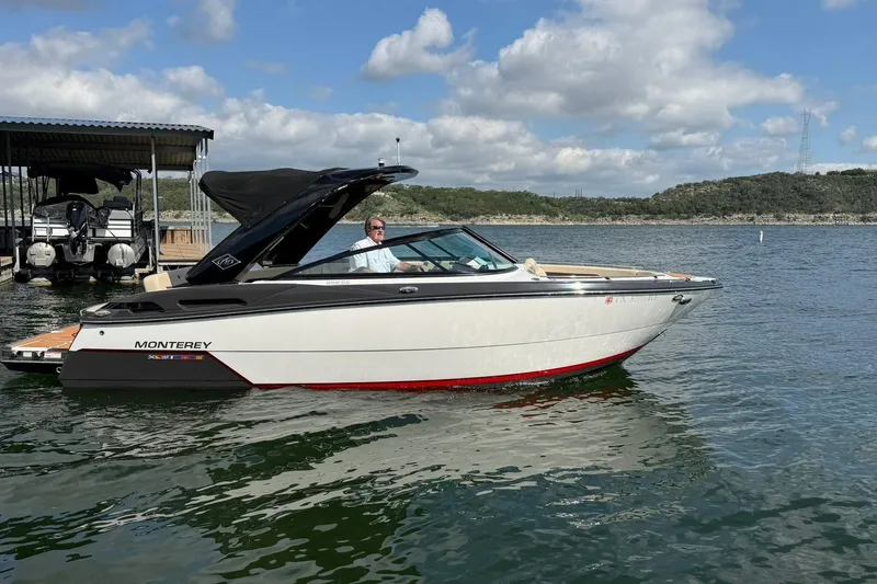 Slide: The Image of 2016 Monterey 258SS Super Sport boat on a lake under a partly cloudy sky. - 19