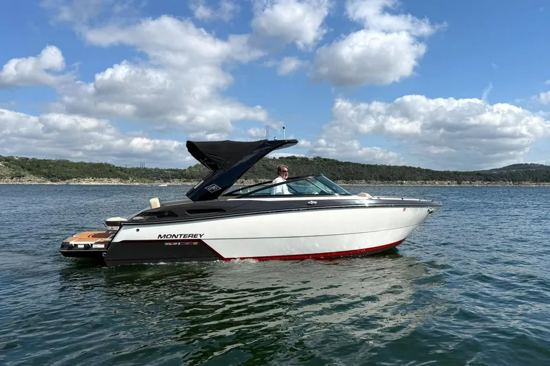 Slide: The Image of 2016 Monterey 258SS Super Sport boat cruising on a scenic lake under a blue sky. - 2
