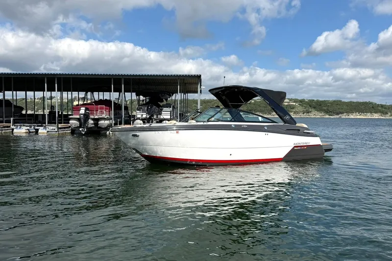 Slide: The Image of 2016 Monterey 258SS Super Sport boat on a lake near a marina under a cloudy sky. - 30