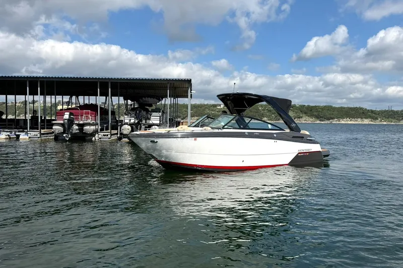 Slide: The Image of 2016 Monterey 258SS Super Sport boat on a lake near a marina under a cloudy sky. - 31