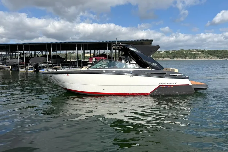 Slide: The Image of 2016 Monterey 258SS Super Sport boat on calm water near a marina. - 8