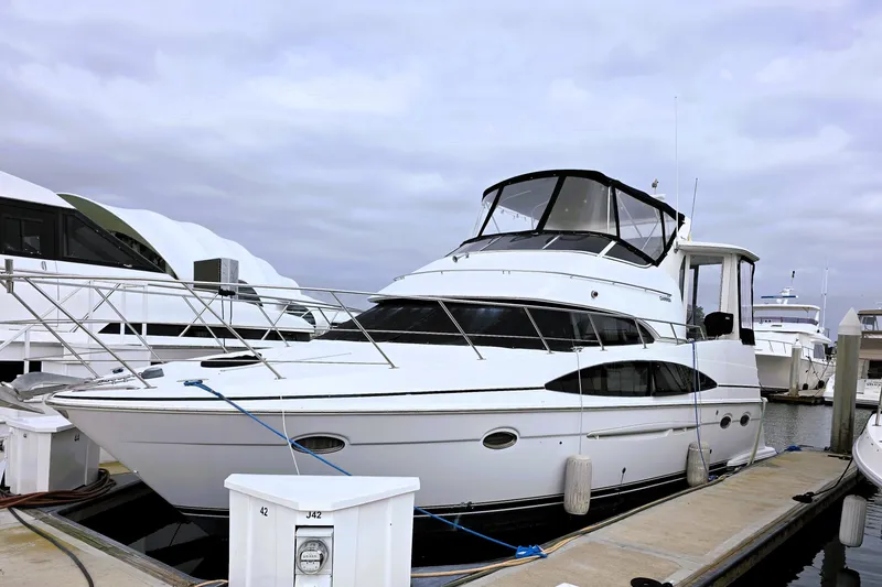 The Image of 2001 Carver 396 Aft Cabin Motor Yacht docked at marina under cloudy sky. - 0