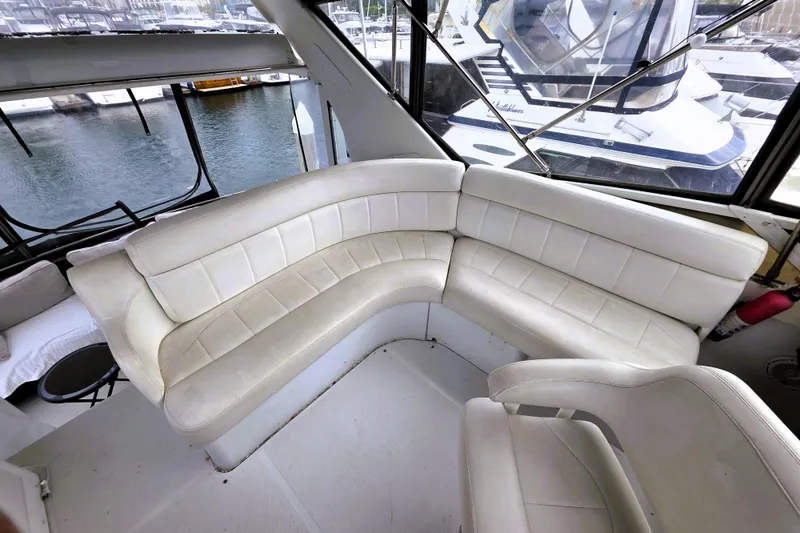 Slide: The Image of 2001 Carver 396 Aft Cabin Motor Yacht interior with white leather seating and marina view. - 20