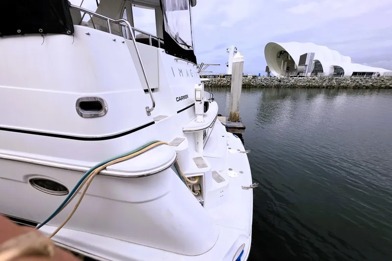 Slide: The Image of 2001 Carver 396 Aft Cabin Motor Yacht docked near modern waterfront architecture. - 22