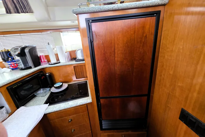 Slide: The Image of Interior of 2001 Carver 396 Aft Cabin Motor Yacht kitchen with appliances and wooden cabinetry. - 6