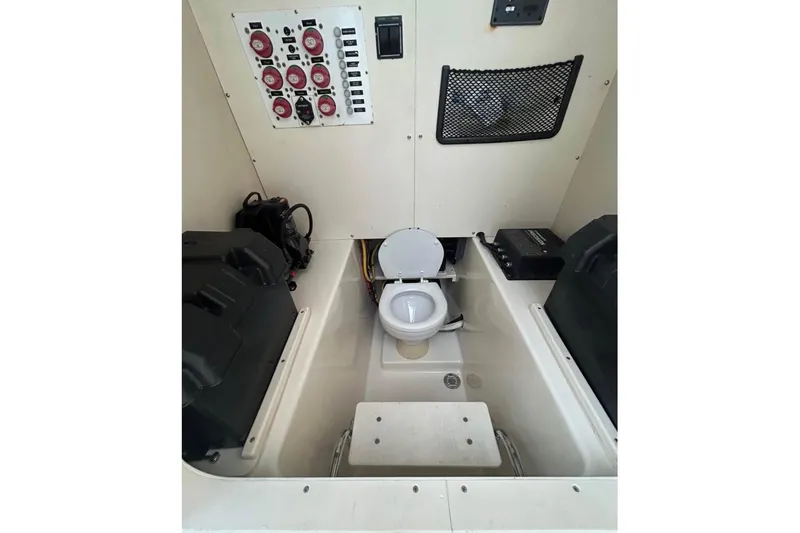 Slide: The Image of 2008 Pursuit C 340 Center Console boat interior with toilet and control panel. - 11