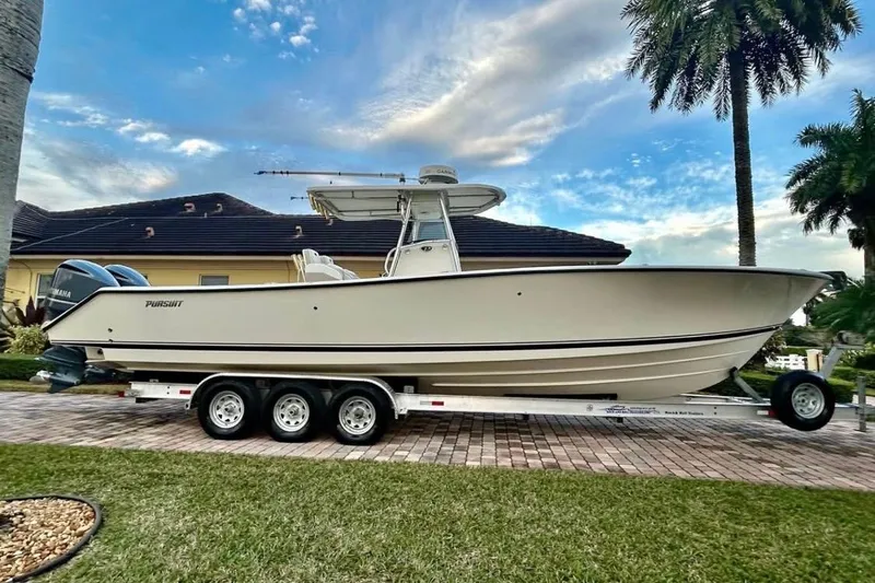 Slide: The Image of 2008 Pursuit C 340 Center Console boat on trailer, parked in driveway. - 2