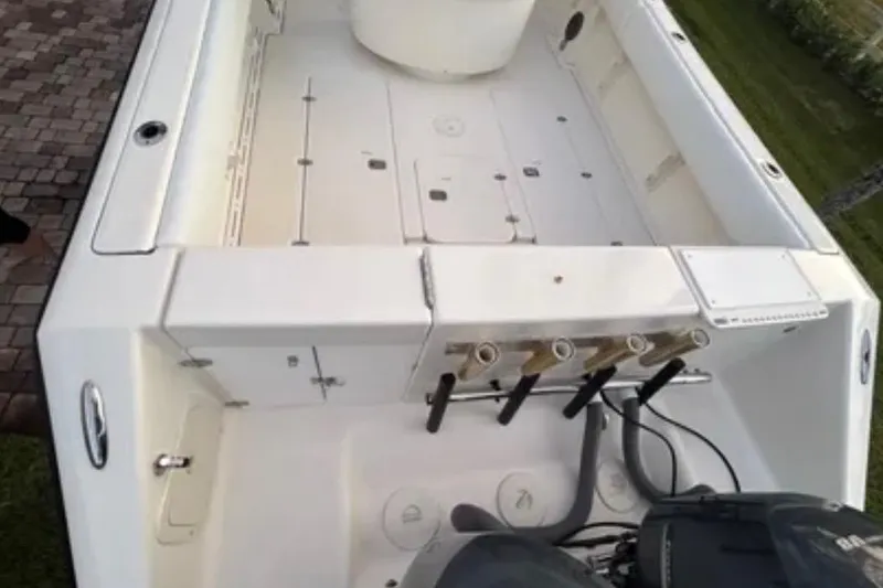 Slide: The Image of 2008 Pursuit C 340 Center Console boat interior with fishing rod holders and engine view. - 5