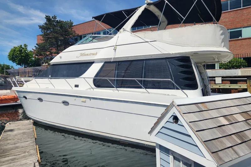 The Image of 1998 Carver 530 Voyager Pilothouse yacht docked at marina, sunny day. - 0