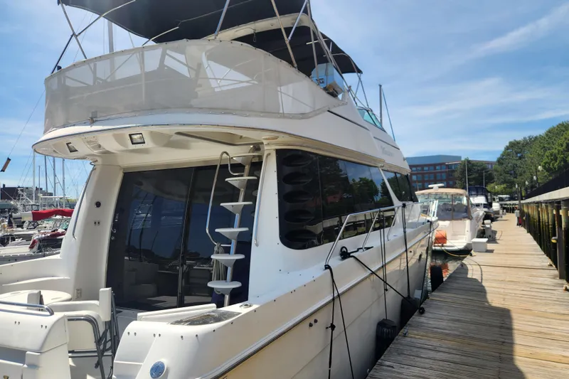 Slide: The Image of 1998 Carver 530 Voyager Pilothouse yacht docked at marina under clear blue sky. - 1