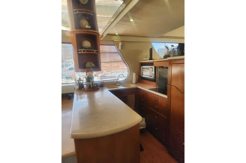 Slide: The Image of Luxurious kitchen interior of 1998 Carver 530 Voyager Pilothouse yacht with wooden cabinetry. - 12