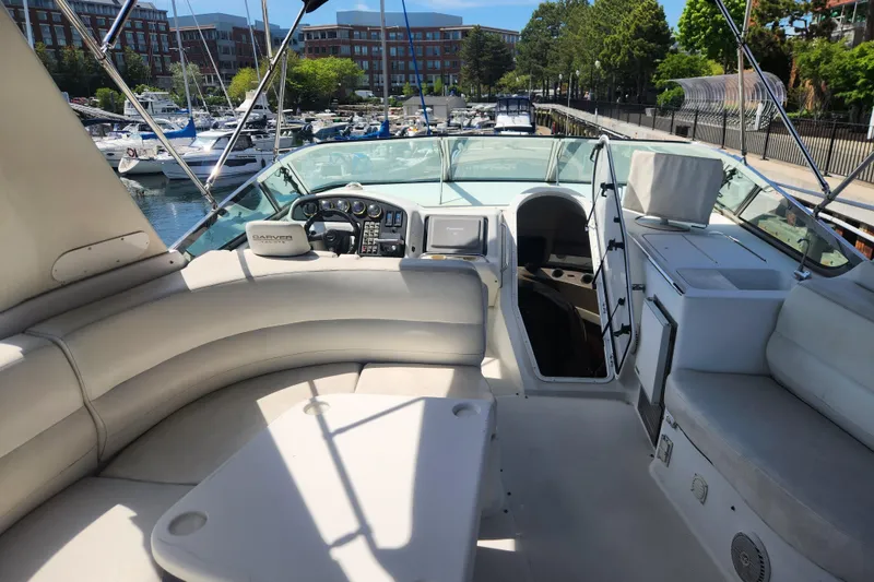 Slide: The Image of 1998 Carver 530 Voyager Pilothouse yacht interior with plush seating and control panel at marina. - 16