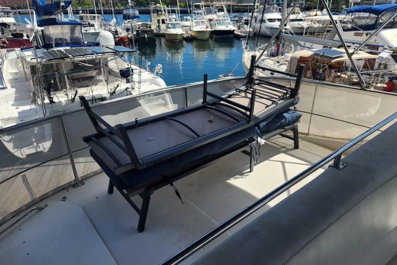 Slide: The Image of 1998 Carver 530 Voyager Pilothouse yacht deck with stacked outdoor furniture in marina. - 18