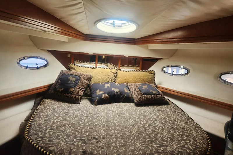 Slide: The Image of Luxurious cabin interior of 1998 Carver 530 Voyager Pilothouse with elegant bedding and portholes. - 19