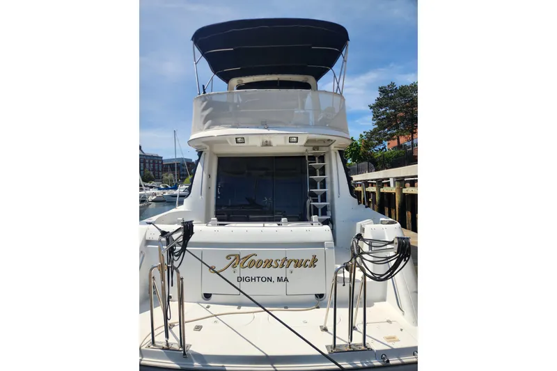 Slide: The Image of 1998 Carver 530 Voyager Pilothouse yacht docked, featuring "Moonstruck" name and Dighton, MA location. - 2